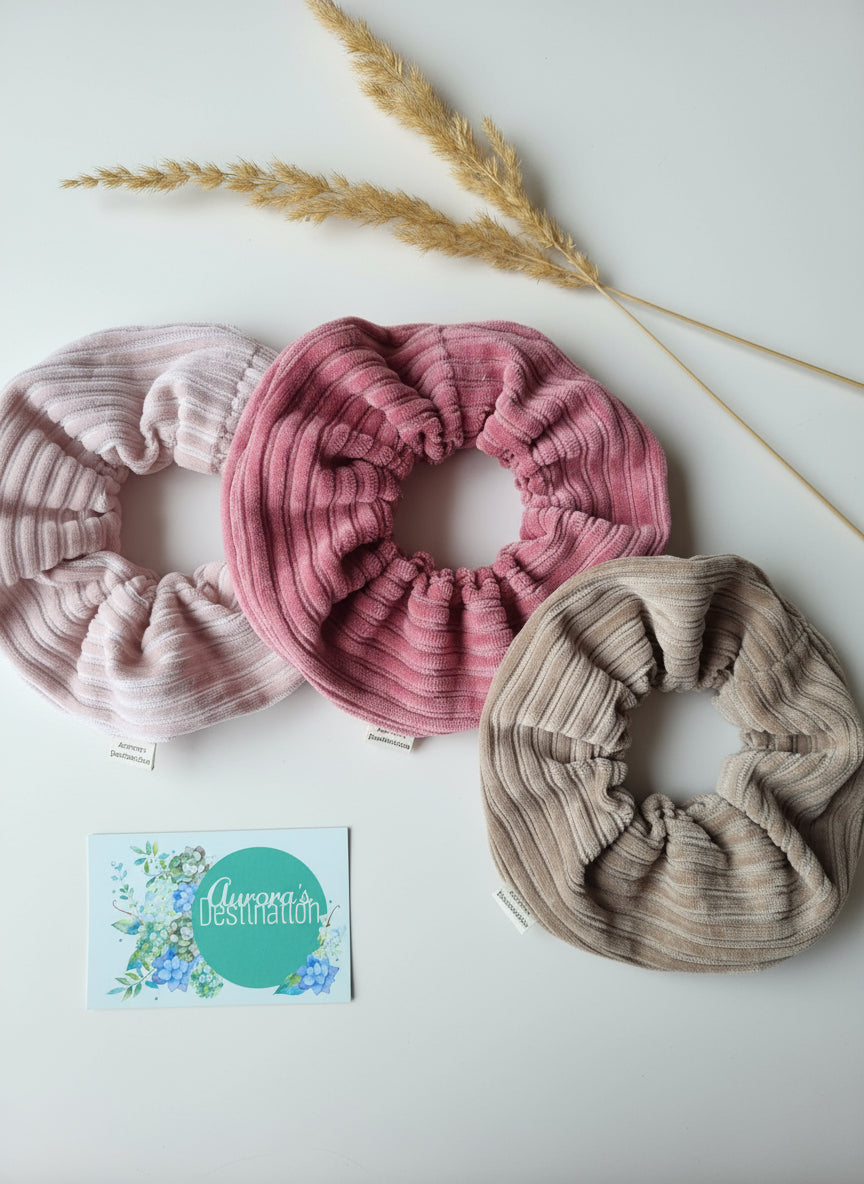 3 handmade chunky cordury scrunchies on a white background to show a selection of colour choices. Minamilist easthestic. Dried flowers in the background.